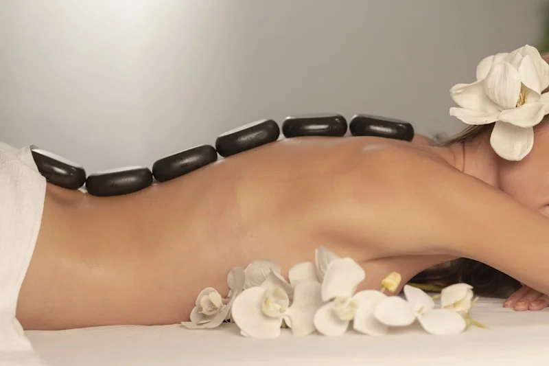 Hot stone massage treatment with orchids